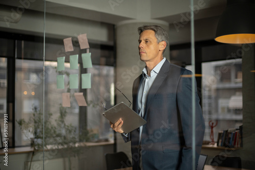 Wallpaper Mural Portrait of successful businessman in office. Man writing ideas on colorful stickers on glass wall.. Torontodigital.ca