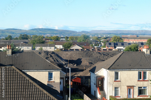 Distant Hills seen over City Roofs on Sunny Day photo