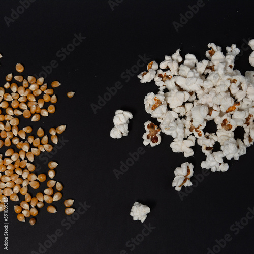 Two piles of popcorn, one pile of ready popcorn, another with corn kernels, popcorn on a black background.