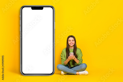 Full length photo of young pretty girl sit floor use mobile app website poster promo isolated over yellow color background