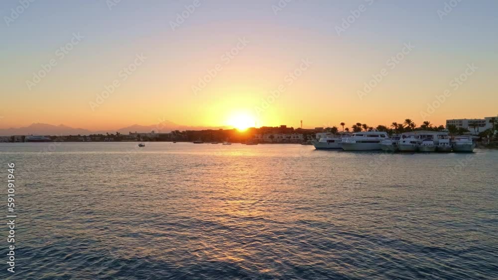 Rotating shot of luxury super yachts docked in harbor along the shoreline with sun setting in the background. Rotating shot of luxury super yachts docked in harbor along the shoreline with sun setting in the background.