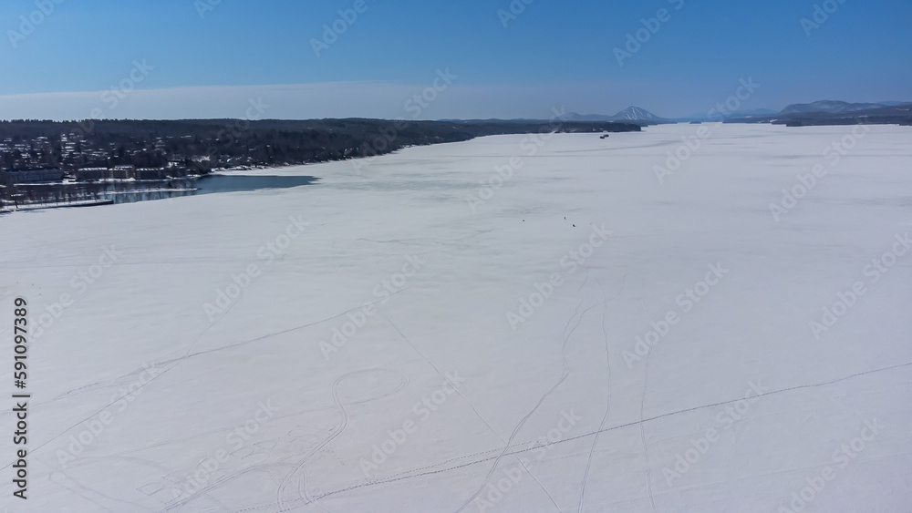 Flying over the cherry river in the Estrie region in winter in Quebec