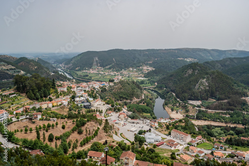 Houses and trees of Penacova village in aerial view with Mondego river between mountains, Coimbra PORTUGAL photo