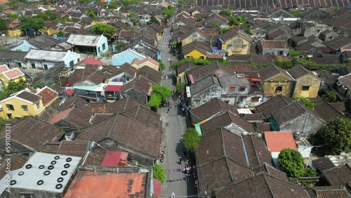Aerial drone footage over Hoi An ancient town a jewel loved by tourist in central Vietnam. Drone is moving foward above the roofs all along the place 6-8 photo