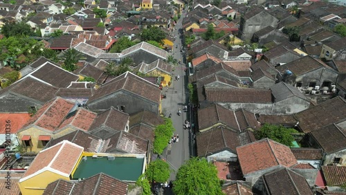 Aerial drone footage over Hoi An ancient town a jewel loved by tourist in central Vietnam. Drone is moving foward above the roofs all along the place 3-8 photo