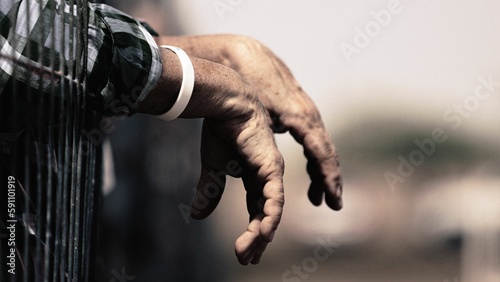 Closeup of male hands leaning on the wire fence - perfect for backgrounds