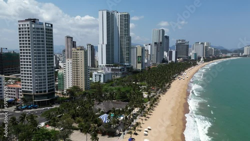 Drone footage above the coastal city of Nha Trang, Khanh Hoa province south Vietnam. Camera is moving backward along the beach and the luxurious hotels 1-3 photo