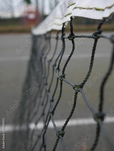 Vertical close-up view of a tennis court net dividing the playground