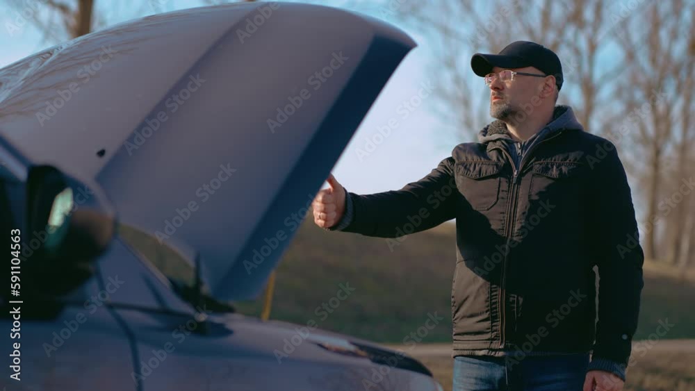 Confused man trying stop car thumb up on side of road and standing near ...