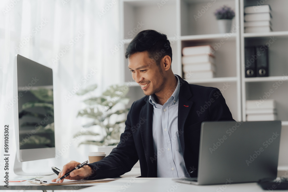 Obraz premium Happy working asian businessman talking on the phone with accounting documents at desk in happy working office