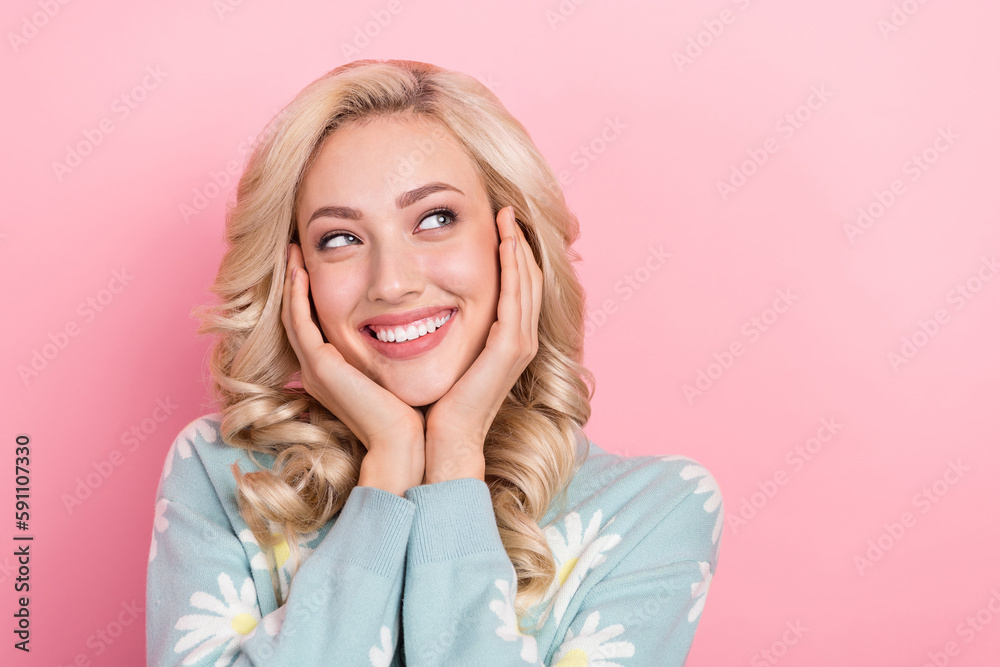 Portrait of positive minded lady beaming smile arms touch cheeks look empty space isolated on pink color background Portrait of positive minded lady beaming smile arms touch cheeks look empty space isolated on pink color background