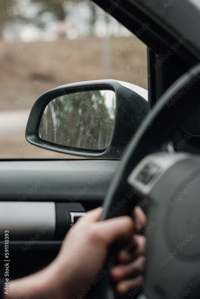 Drivers's hands on a left stearing,steering wheel of a car