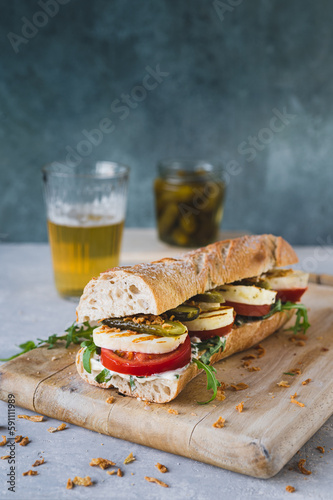 Sandwich mit  Halloumi, Gewürzgurke, Röstzwiebeln,  Tomate und Rucola 