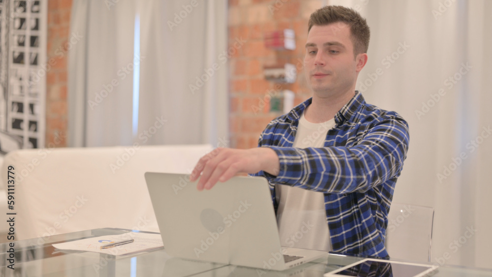 Young Casual Man Leaving Room after Closing Laptop 