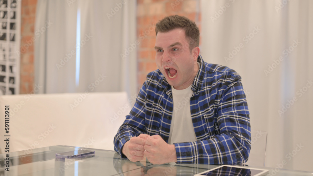 Angry Young Casual Man in Frustration Sitting in Office Angry Young Casual Man in Frustration Sitting in Office