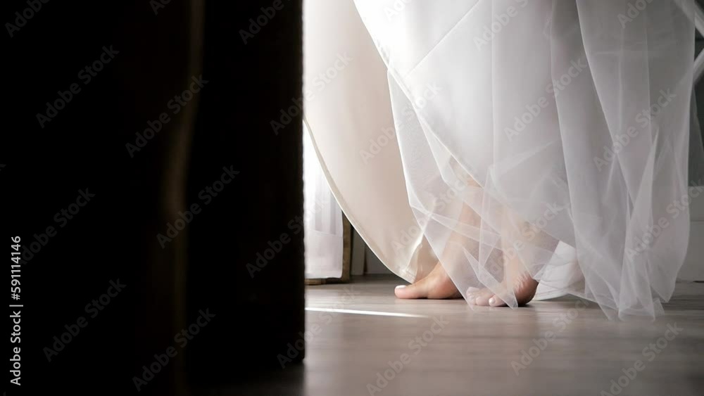 A bride in a long white wedding dress walks barefoot on the floor. Preparing for wedding ceremony, reception. High quality FullHD footage with slow motion A bride in a long white wedding dress walks barefoot on the floor. Preparing for wedding ceremony, reception. High quality FullHD footage with slow motion