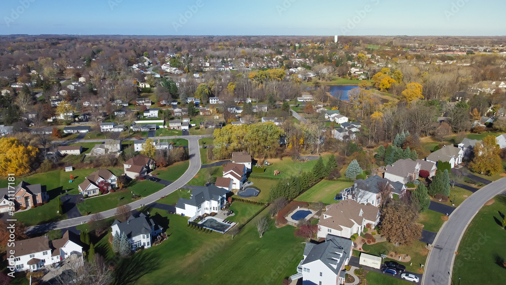 Lakeside master planned community low density housing, row of two-story houses on grassy yards, no fence, colorful fall foliage to horizontal line Rochester, New York, USA