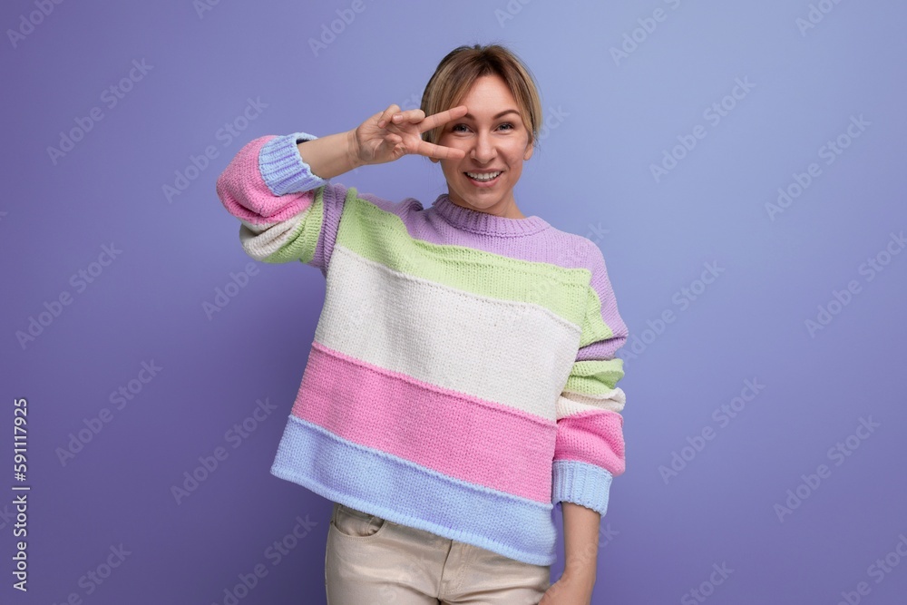 smiling blond young woman flirting at camera on purple background with copy space smiling blond young woman flirting at camera on purple background with copy space