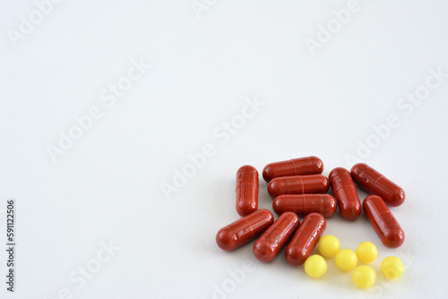 Red pills with yellow pills on a white background isolated, copy space 