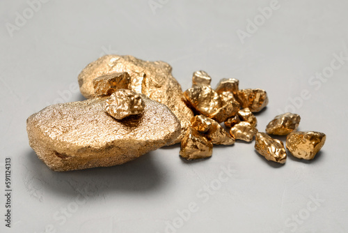 Pile of gold nuggets on light grey table