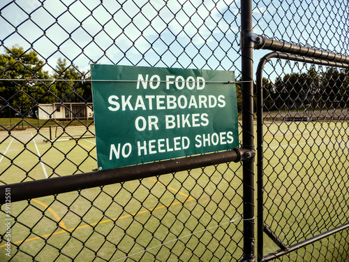 No food, skateboards or bikes, no heeled shoes sign at tennis court