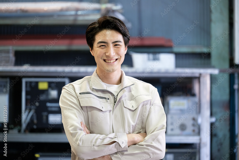 Obraz premium Image of a man in work clothes, arms folded, looking at the camera