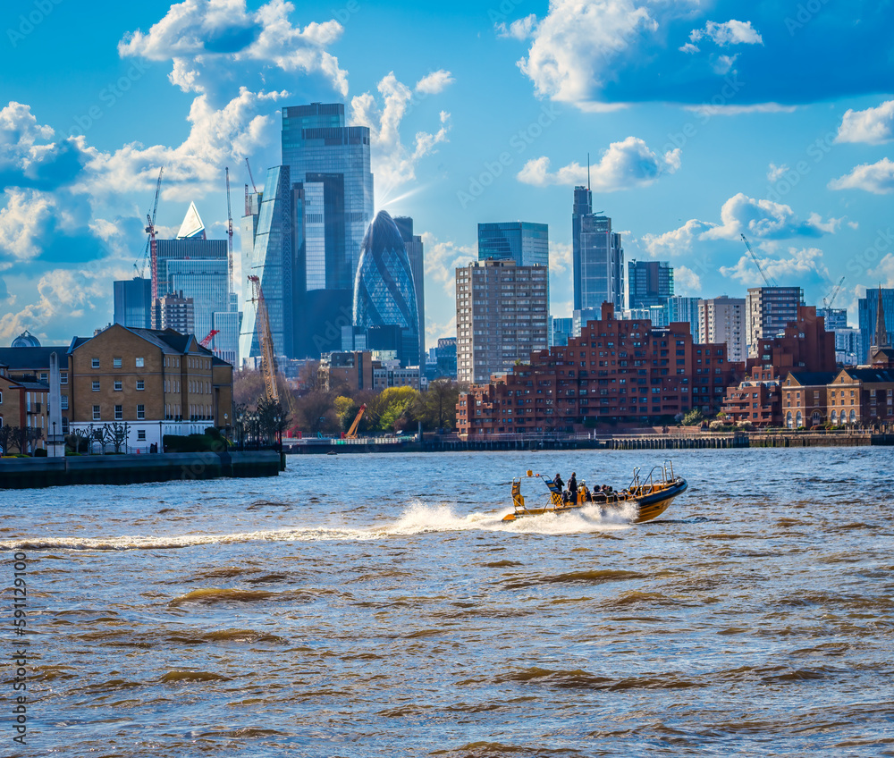 A speed boat on the Thames with central London buildings in the background 