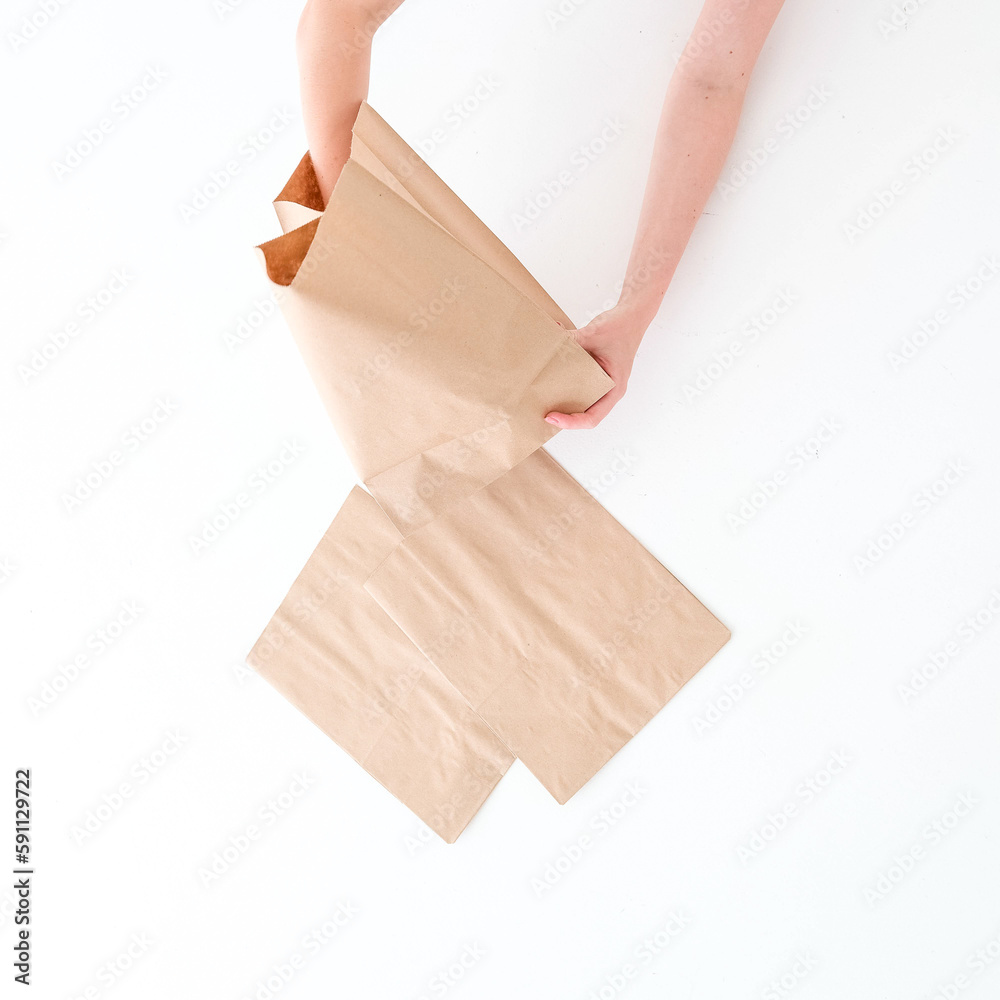 Craft bags on a white background with a hand. Place for text and logo. Top view. The concept of packaging, delivery, food.