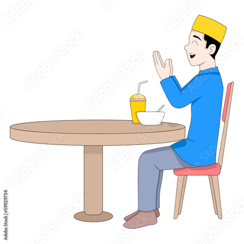 Muslim boy is sitting praying going to eat iftar