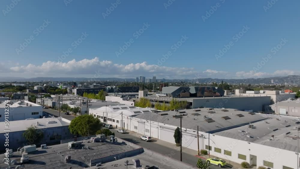 Forwards fly above town development in Culver City. Low buildings and downtown skyscrapers in distance. Los Angeles, California, USA Forwards fly above town development in Culver City. Low buildings and downtown skyscrapers in distance. Los Angeles, California, USA