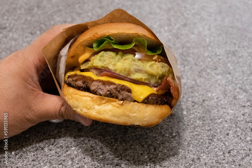 a hand holding a hamburger