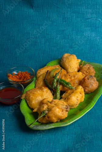 Indian Tea time snacks in group includes Veg Samosa, Kachori/kachaudi, aloo bonda, khaman dhokla, bread, onion,chilli and moong pakora/pakoda/bhaji/bhajji/Bhajiya/bajji with sauces, selective focus photo