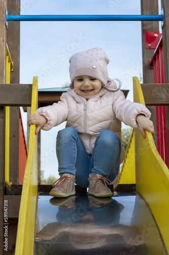 Bambina di tre anni mentre gioca sullo scivolo