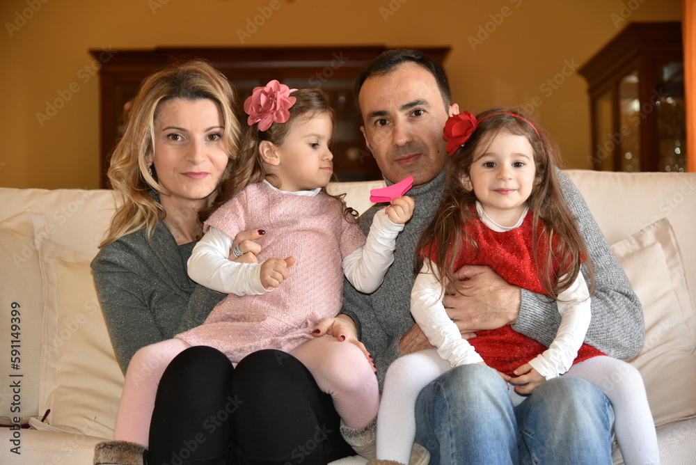 Ritratto di famiglia con padre, madre e le figlie gemelle di tre anni. Ritratto di famiglia con padre, madre e le figlie gemelle di tre anni.