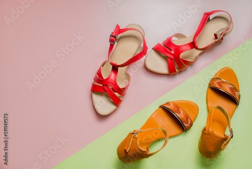 Two pair of red and gold shoes on soft green and pink background