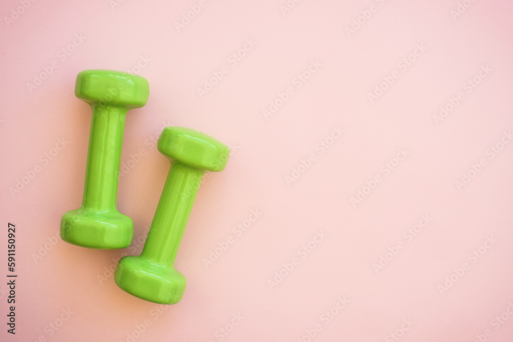 Green Dumbbells on pink. Flat lay image with copy space. Green Dumbbells on pink. Flat lay image with copy space.