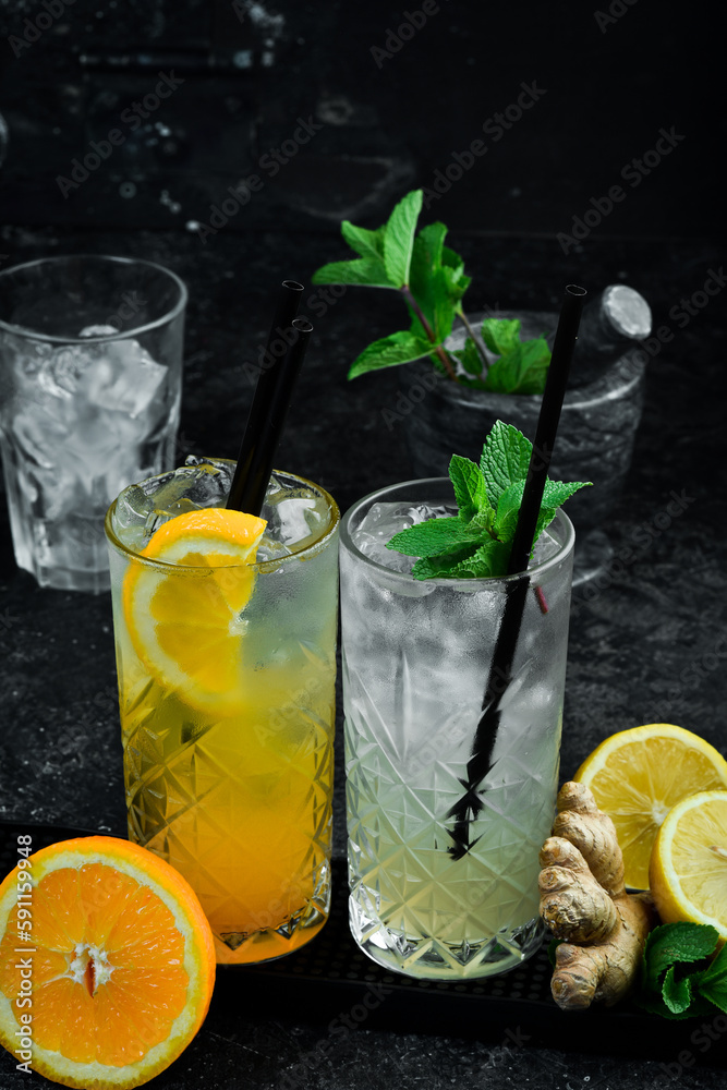 Fototapeta premium Set of colored cocktails. A set of lemonades. Bar counter with drinks. Banner. On a black background.