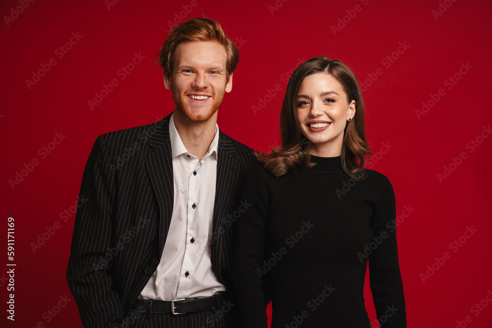 Beautiful couple posing isolated over red wall Beautiful couple posing isolated over red wall