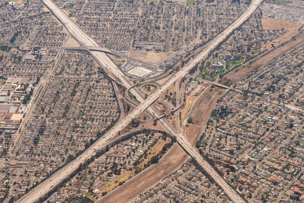 Fototapeta premium Aerial view of the interchange of the I-5 Santa Ana Freeway and the I-605 San Gabriel Freeway with the San Gabriel River and Wilderness Park in Santa Fe Springs