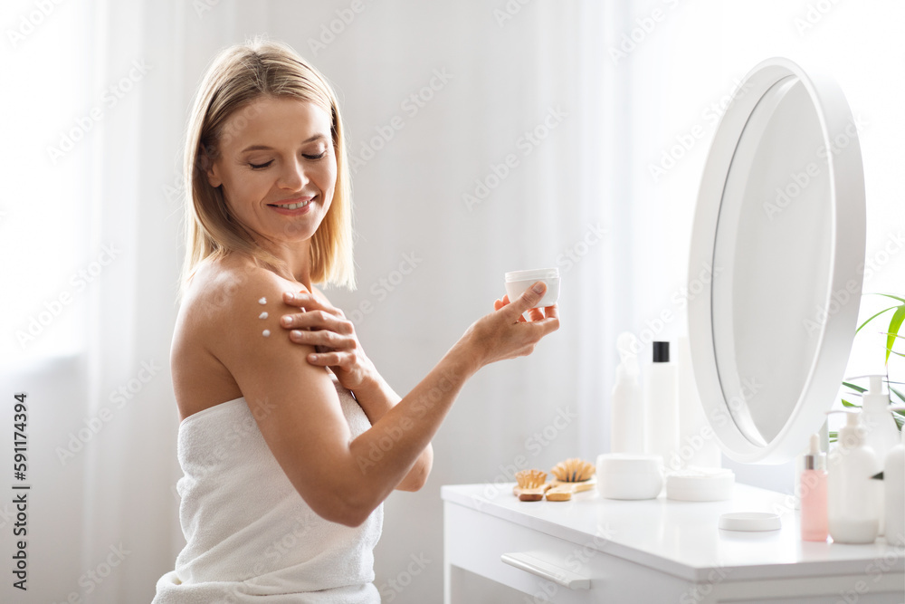 Skin Nourishing. Middle Aged Woman Applying Moisturising Cream On Shoulder At Home Skin Nourishing. Middle Aged Woman Applying Moisturising Cream On Shoulder At Home