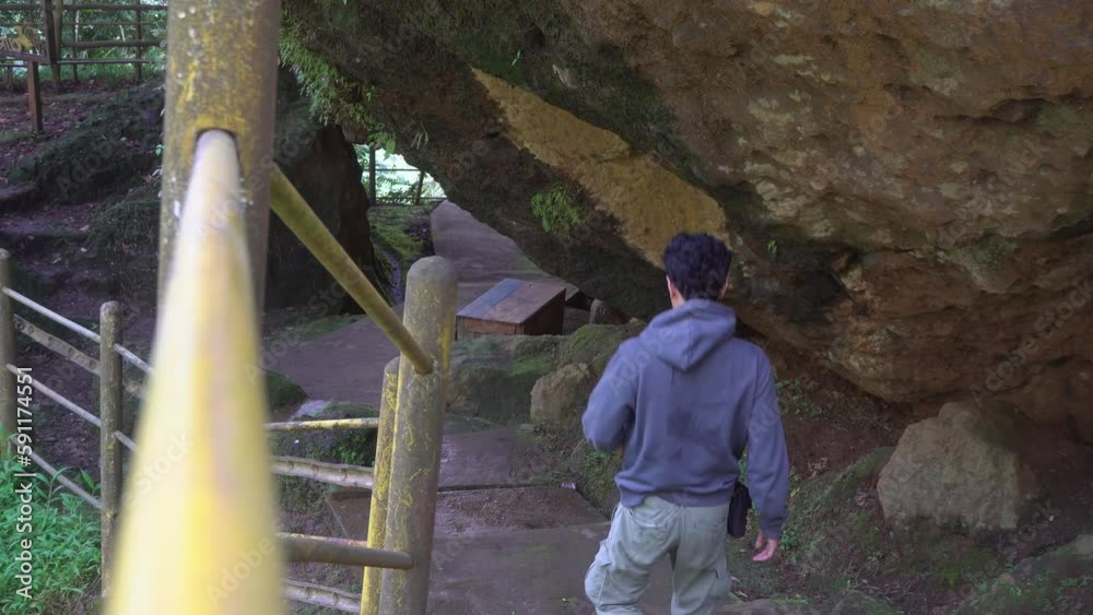 Man walking on the cave that popular travel destination on Semarang Central Java. The photo is suitable to use for adventure content media, nature poster and forest background. Man walking on the cave that popular travel destination on Semarang Central Java. The photo is suitable to use for adventure content media, nature poster and forest background.