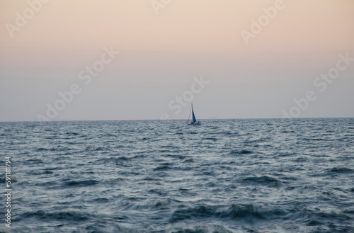 Lonely boat at sea, sailboat in the distance on the high seas © Stanislaw