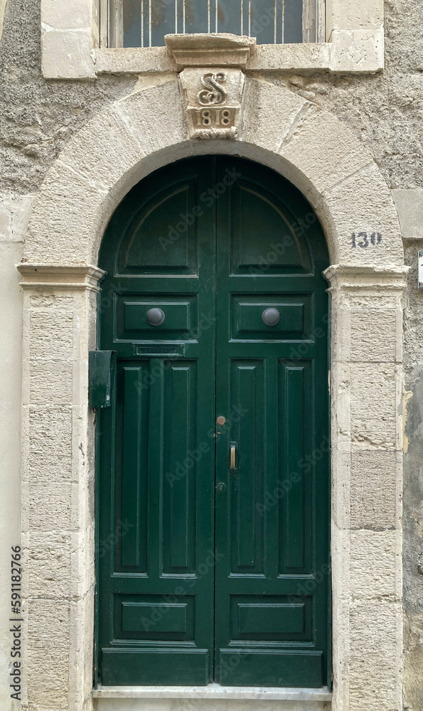 18th century intricately hand-carved, dark green wooden door & archway in Sicily.