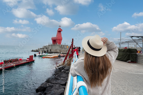 Lady tourist travel at Lighthouse of Iho tewoo Beach, Jeju Island, South Korea