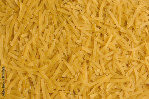Yellow background with raw vermicelli noodles. Concept - pasta as background.