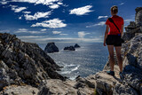 Young Woman Stand At The Edge Of The Cliffs At Pointe De Penhir At The Finistere Atlantic Coast in Brittany, France
