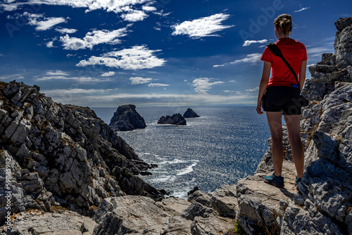 Young Woman Stand At The Edge Of The Cliffs At Pointe De Penhir At The Finistere Atlantic Coast in Brittany, France