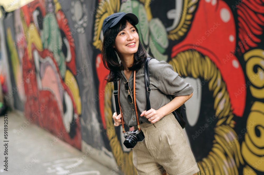 Young Asian woman backpack traveler enjoying street cultural local place and smile. Traveler checking out side streets.