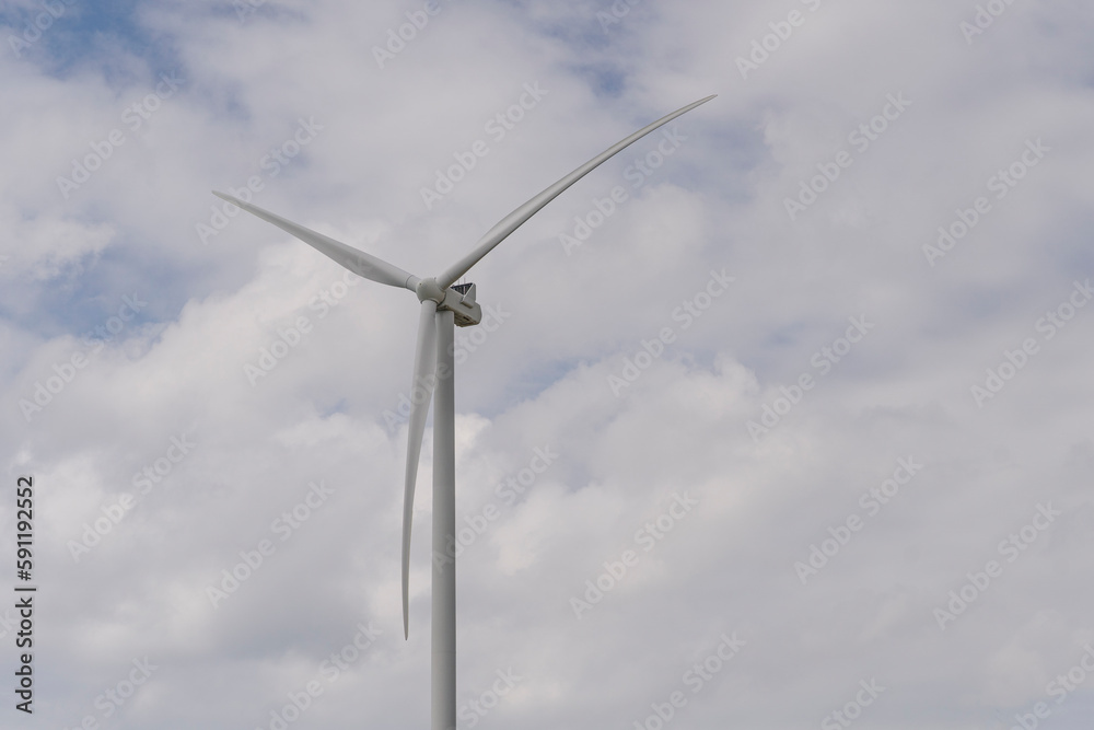 Wind farm with tall wind turbines to generate electricity. Green energy concept. Wind farm with tall wind turbines to generate electricity. Green energy concept.