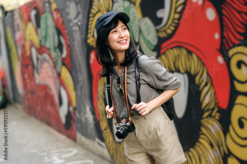 Young Asian woman backpack traveler enjoying street cultural local place and smile. Traveler checking out side streets.